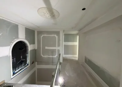 Decorative ceiling rose and cornice in Clayfield with an arched window and stairwell jointed