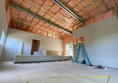 Plasterboard installer work with wall sheeting stacked ready for an open raked ceiling