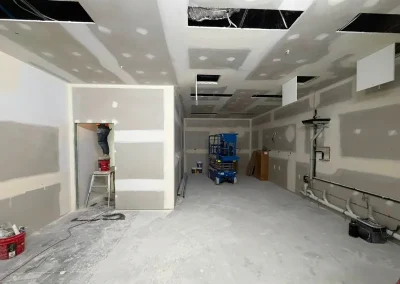 Plasterer contractors jointing ceiling access panels at a commercial fit-out in Milton