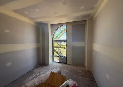 Wall repairs in New Farm with jointing compound applied around an arched window before sanding